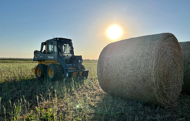 Skidsteer mid-summer with Hay Bales